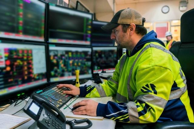 An International Paper employees works at a busy control center